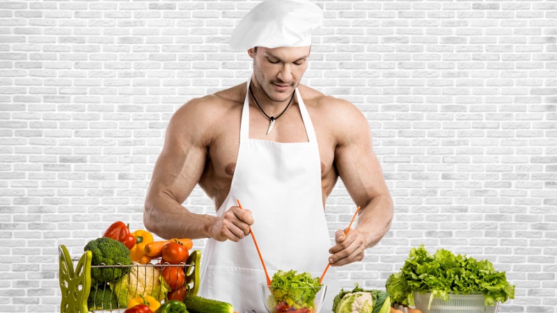 مرد بدنساز در حال آشپزی