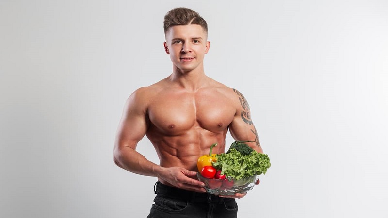 یک مرد ورزشکار با سبزیجات در دست