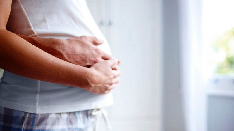 یک خانم باردار که دستانش بر روی شکمش است