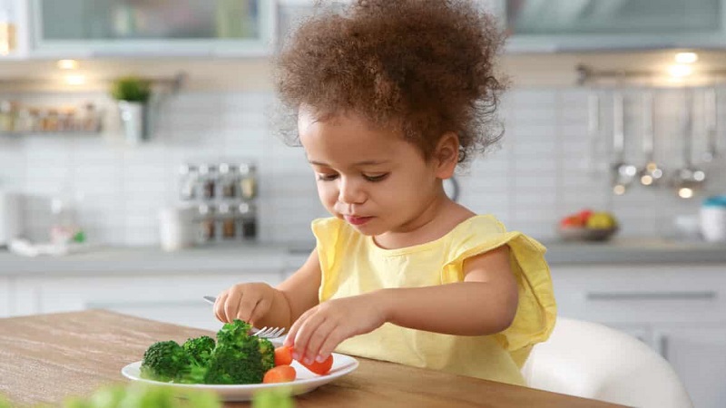 کودک در حال خوردن سبزیجات