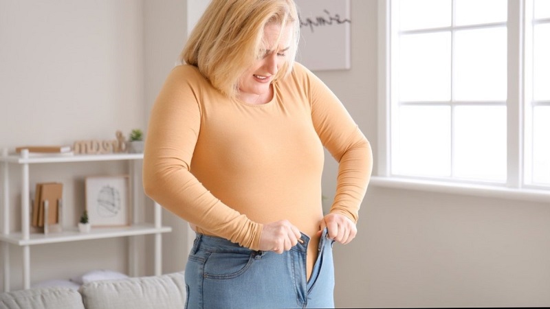 یک خانم دارای اضافه وزن که قادر به بستن زیپ شلوار خود نیست
