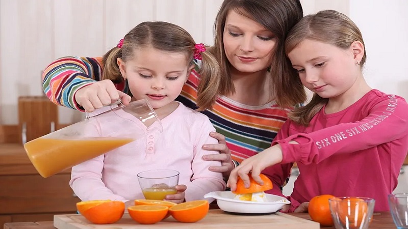 مادر و دو فرزند در حال خوردن آب پرتغال