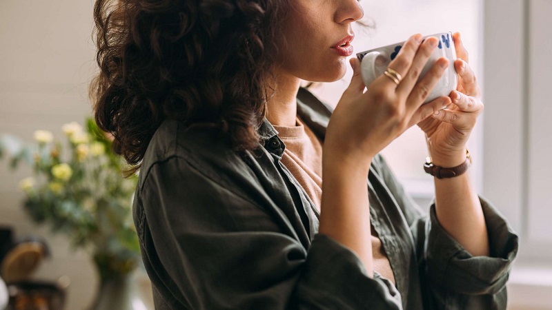 یک خانم در حال نوشیدن قهوه